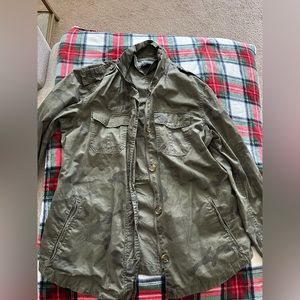 Army green, camouflage print windbreaker style jacket with waist cinch detail.